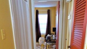 A hallway with a tiled floor leading to a room with a desk and chair. - #3 UAB KING SUITE+2 MIN WALK TO RESTAURANT (Birmingham)