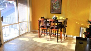 A dining area with a table and chairs, a sliding glass door, and a ceiling light fixture. - #3 UAB KING SUITE+2 MIN WALK TO RESTAURANT (Birmingham)