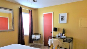 A hotel room with a bed, a chair, a desk, and a door. - #3 UAB KING SUITE+2 MIN WALK TO RESTAURANT (Birmingham)