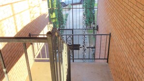 A staircase leading to a gated driveway with a car parked outside. - #3 UAB KING SUITE+2 MIN WALK TO RESTAURANT (Birmingham)