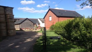 Entrada a una granja rural con un letrero que dice "PYESMEAD FARM".