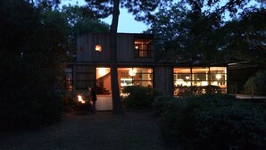 Ein modernes Haus mit Glasfassade, umgeben von Bäumen.