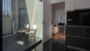 Une cuisine moderne avec un plan de travail noir et un réfrigérateur en acier inoxydable.