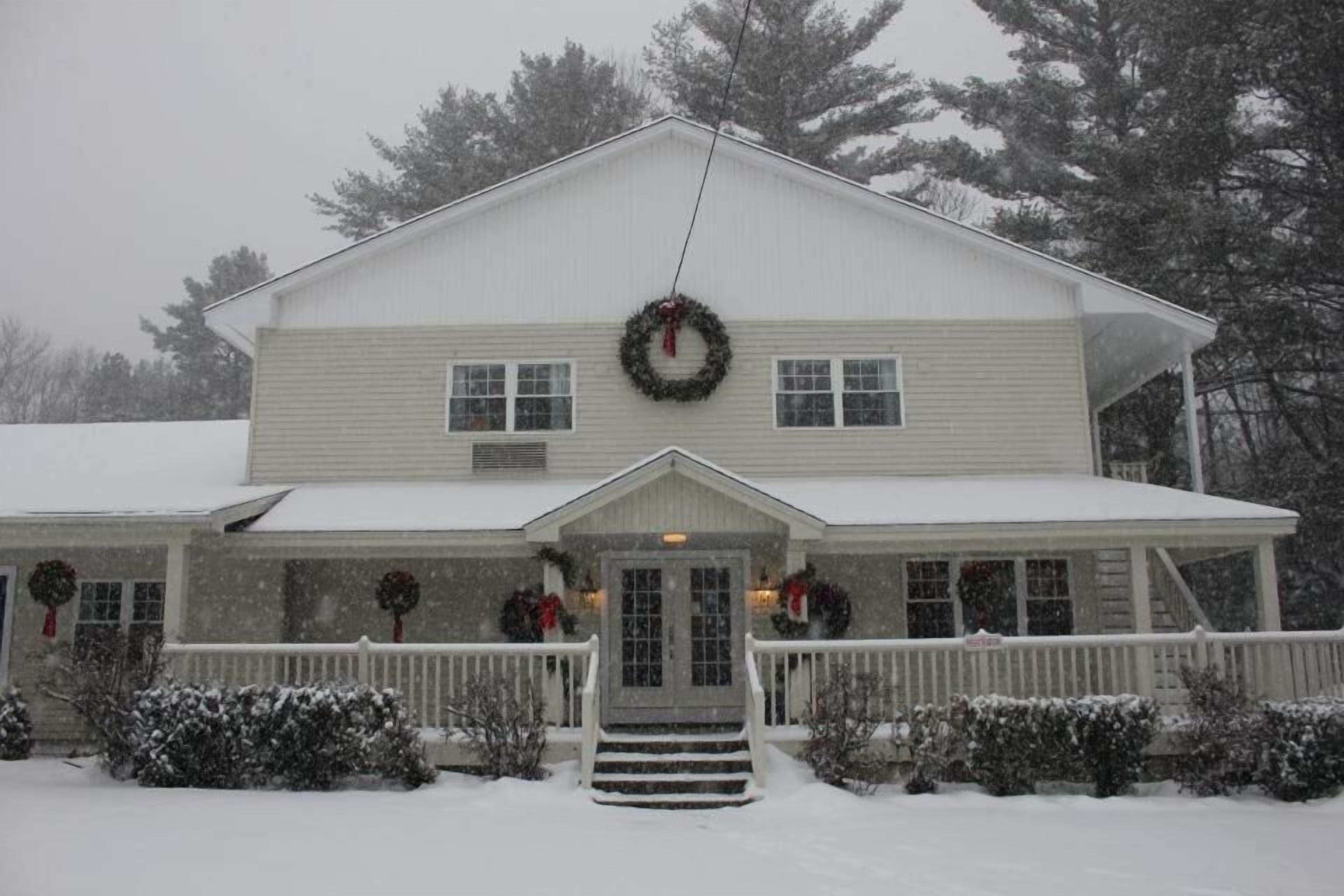 A two-story house with a front porch, a front door, and a chimney.