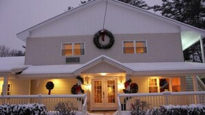 A two-story house with a front porch, a front door, and a staircase leading up to the entrance. - Golden Apple Inn (Glen)