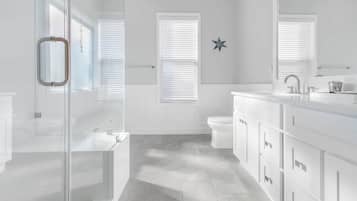 Une salle de bain moderne avec une douche à parois de verre, un lavabo blanc et un grand miroir.