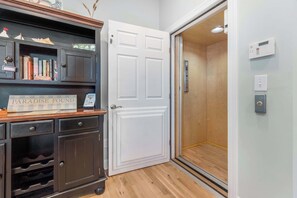 Une chambre d’hôtel avec un meuble en bois, une porte blanche et un plancher en bois.