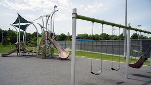 A playground with swings, a slide, and climbing structures. - Tomar Park Apt 3 - KP101APT3 (Sioux Falls)