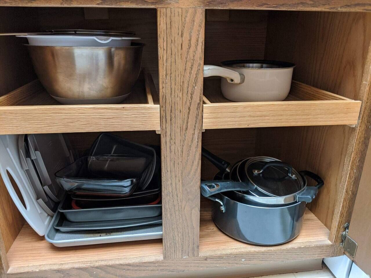 Un meuble en bois doté d’étagères où sont rangés les ustensiles de cuisine.
