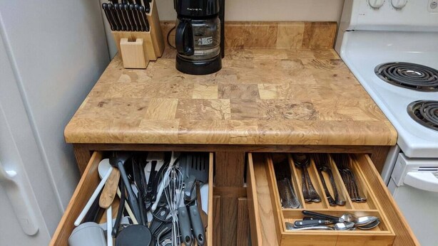 A kitchen with a wooden countertop, two drawers below for utensils, and a coffee maker on the counter. - Tomar Park Apt 3 - KP101APT3 (Sioux Falls)