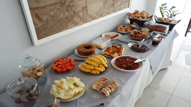 Buffet amb diverses plats, incloent fruita, pastissos i postres.