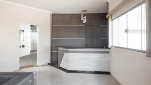 Una cuina moderna amb una illa integrada, un gran finestral i una porta que condueix a una altra habitació.