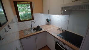 Una cocina compacta con un fregadero, estufa y armarios.