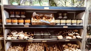 A grocery store shelf stocked with various food items including jars of spices, mushrooms, and packaged goods. - 30% Discount Beautiful converted studio apartment in idyllic Cotswold village! (Cirencester)