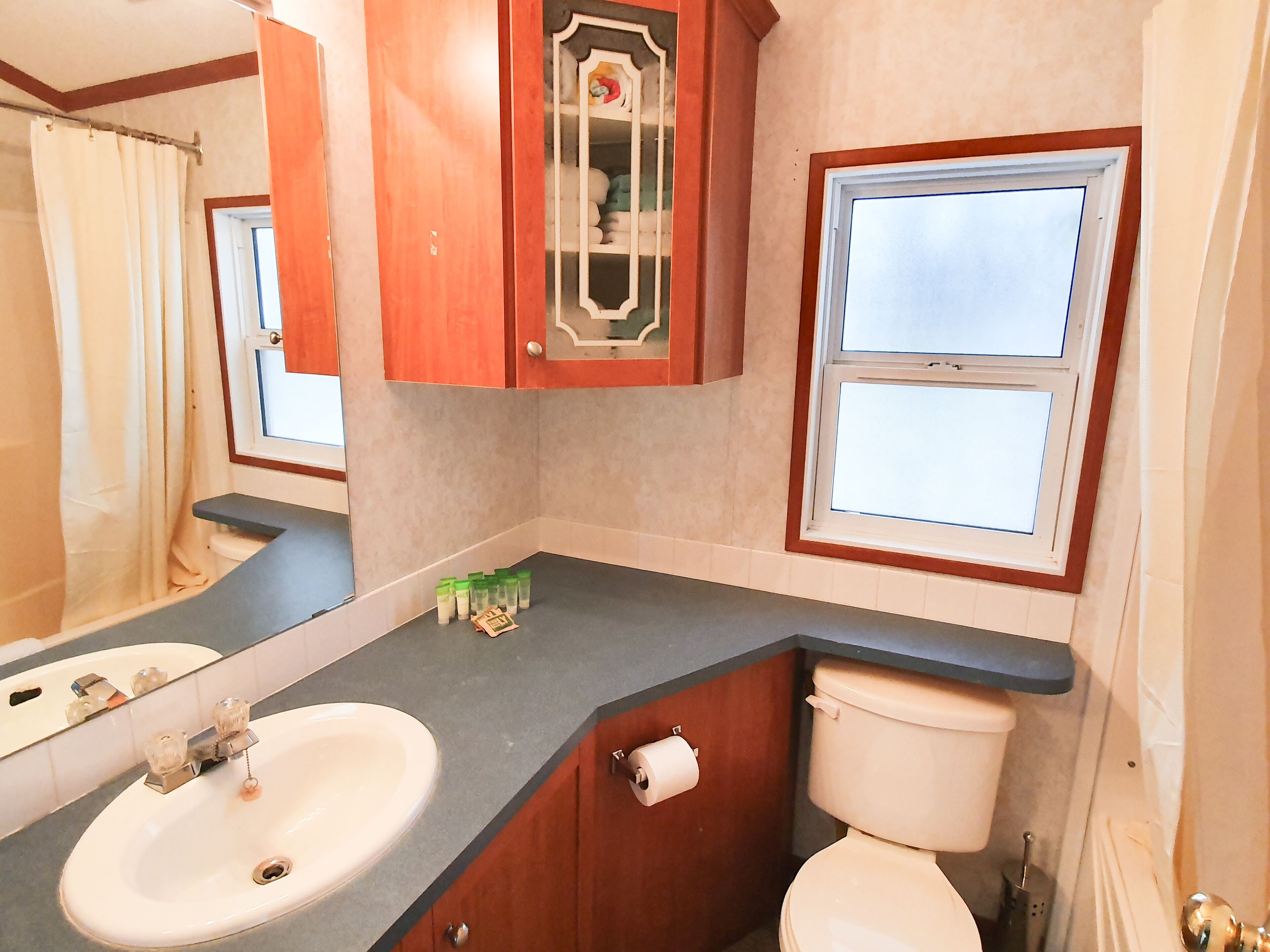 Un baño con dos lavabos, un inodoro y un espejo.