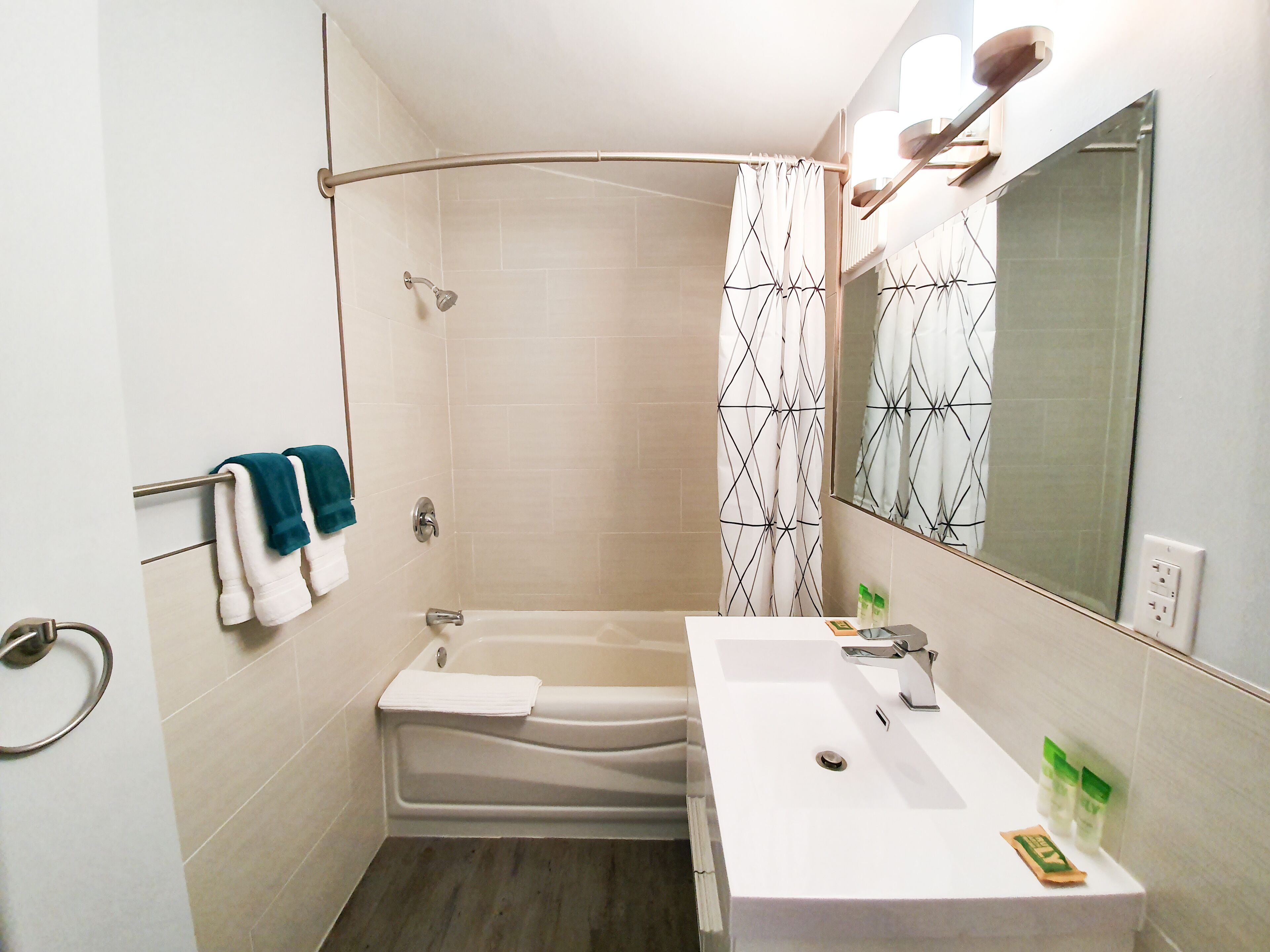 Un baño moderno con ducha, bañera, lavabo y espejo.