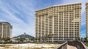 Un hotel moderno de altura con varios balcones y vista al mar.