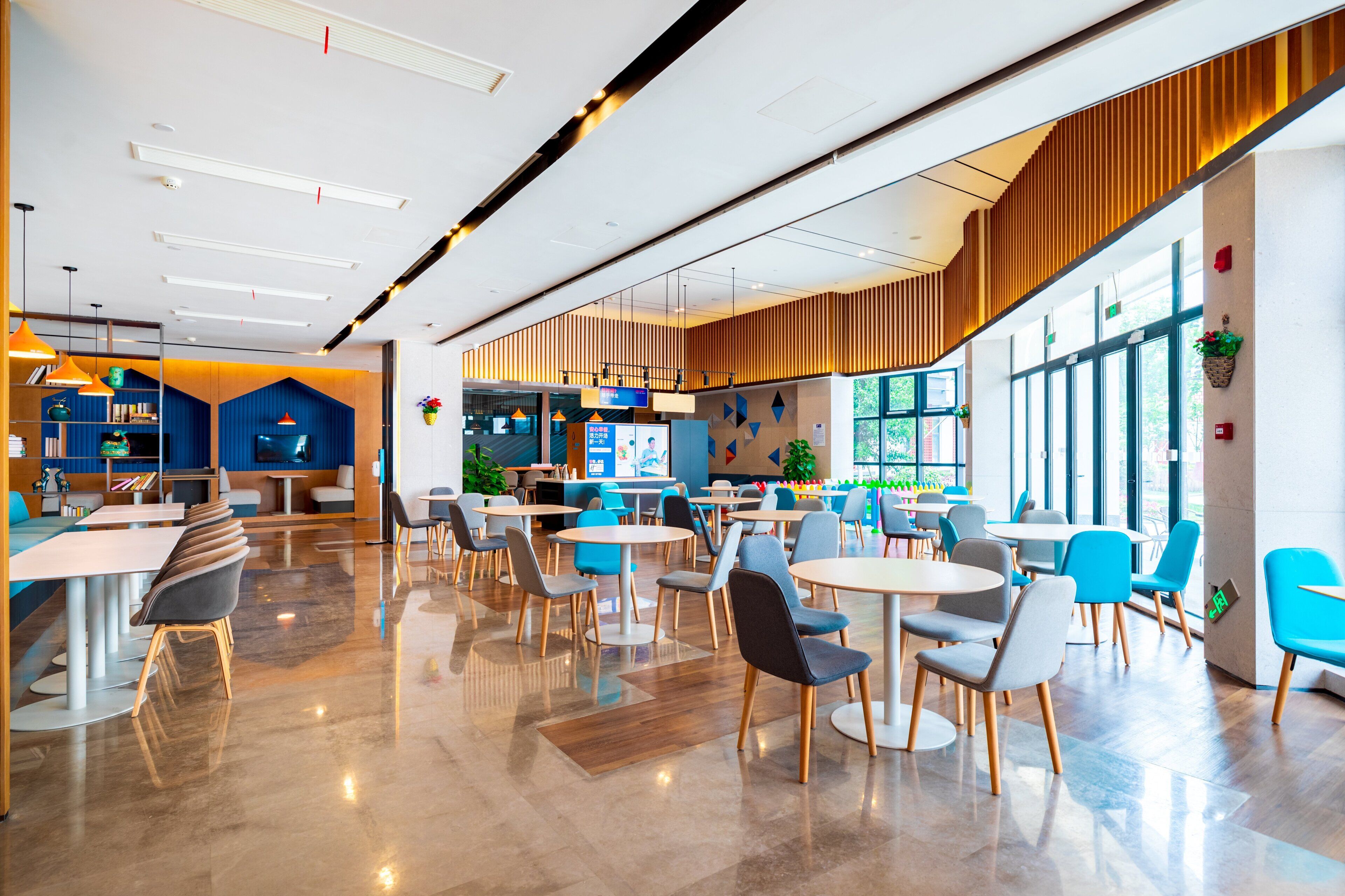 Una cafetería moderna con diversas opciones de asientos, incluyendo mesas, sillas y una barra.