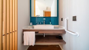 A modern bathroom with a white sink, a mirror, and a blue tiled wall. - Holiday Inn Express Pinghu by IHG (Jiaxing)
