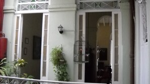 A building facade with arched windows and a balcony railing. - Casa Novo Guest House CENTRO HABANA (Havana)