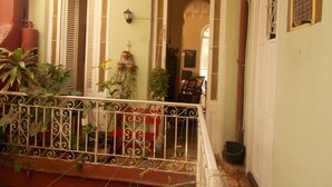 A balcony with ornate metal railings, potted plants, and a view of the interior through an open doorway. - Casa Novo Guest House CENTRO HABANA (Havana)