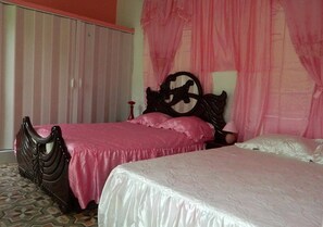 Un dormitorio con dos camas, una con cabecera de madera y la otra con cabecera sencilla.