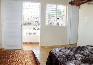 A bedroom with a bed, a door, and a window. - Hostal El Corojo TRINIDAD (Trinidad)