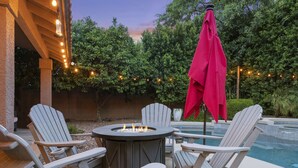 An outdoor patio with Adirondack chairs, a fire pit, and a pool. - Stunning North Scottsdale Home w/Heated Pool and Hot Tub (Scottsdale)