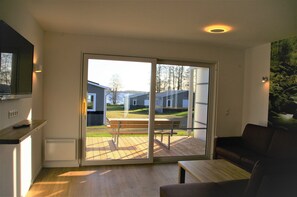 Moderni olohuone, jossa on liukuovet, jotka johtavat ulkoterasille.