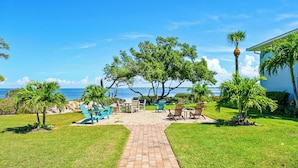 A paved pathway leading to outdoor seating with a view of the ocean. - West Bay Cove 231 · Skyway Views · Sun Room (Holmes Beach)
