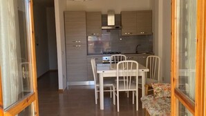 Una cocina moderna con comedor, que incluye una mesa, sillas y un banco con cojín floral.