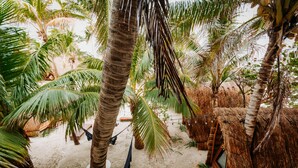 A sandy area with palm trees and a hammock. - Nílu Isla Mujeres by Selina (Isla Mujeres)