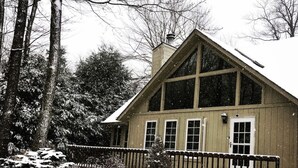 A wooden cabin with a gabled roof, large windows, and a snow-covered landscape. - Escape to ‘Pursue Happiness’ - Your Poconos Retreat! (Tobyhanna)