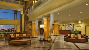 A spacious lobby with high ceilings, a reception desk, and comfortable seating areas.
