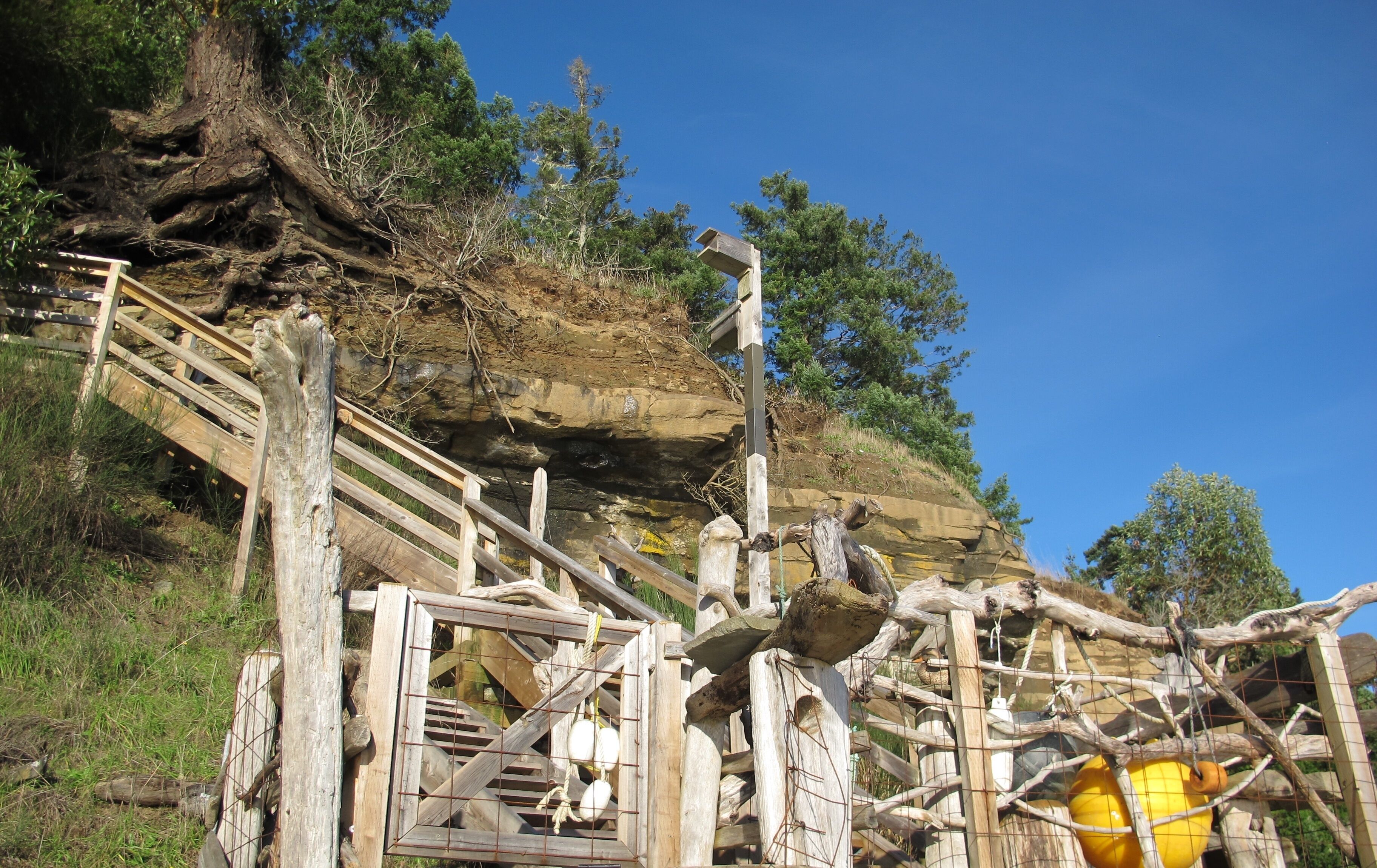 A wooden staircase leading up a rocky hillside with a metal railing.
