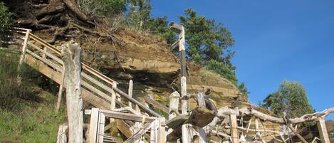 A wooden staircase leading up a rocky hillside with a metal railing.
