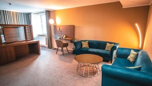 Un salon moderne avec un canapé, un fauteuil et une table basse.