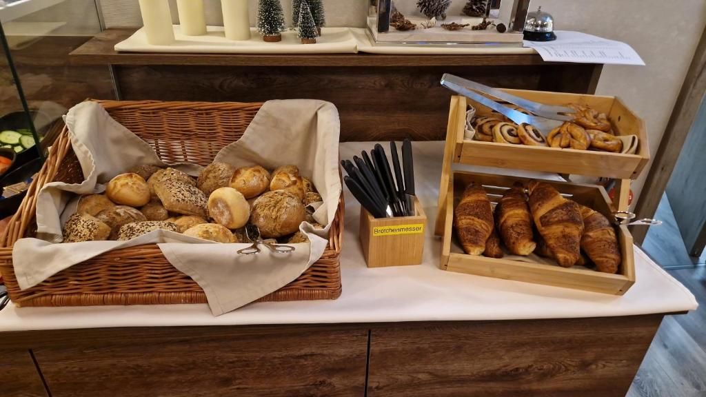 Una barra de buffet con varios panes y pasteles, un bloque de cuchillos y una exhibición de adornos navideños.