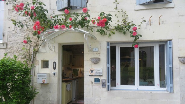 A quaint building with a small entrance, a visible kitchen area, and a window with shutters. - 3- Star small town cutie on the Charente River (Bourg-Charente)
