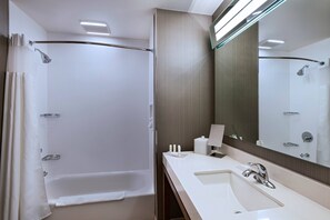 A modern bathroom with a bathtub, a sink, and a large mirror. - Courtyard by Marriott Dallas Grand Prairie (Grand Prairie)