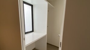 Una habitación con techo inclinado, una ventana y una puerta.