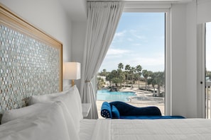 A hotel room with a bed, a view of a swimming pool, and a balcony. - 3rd Floor Condo with Stunning Views and Wrap Around Balcony (Destin)