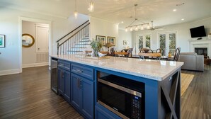 A spacious kitchen with a large island, built-in appliances, and pendant lighting. - EXPANSIVE PORCH-Gulf Breezes-Beach Views & Gorgeous Oak tree (Pass Christian)