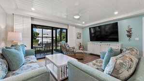 A spacious living area with a large TV, comfortable seating, and a view of the outdoors. - Newly Renovated Dock View 2 bed, 2 bath at Sanibel Moorings #1641 (Sanibel)