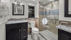 A modern bathroom with a glass-enclosed shower, a vanity with a marble countertop, and a toilet. - Newly Renovated Dock View 2 bed, 2 bath at Sanibel Moorings #1641 (Sanibel)