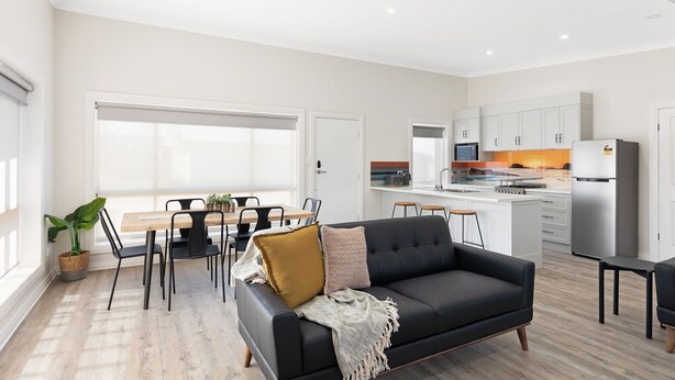 A modern kitchen with white cabinets, a built-in microwave, and a stainless steel refrigerator.