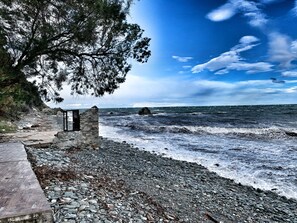 Une plage rocheuse avec une structure en pierre et une promenade en bois.