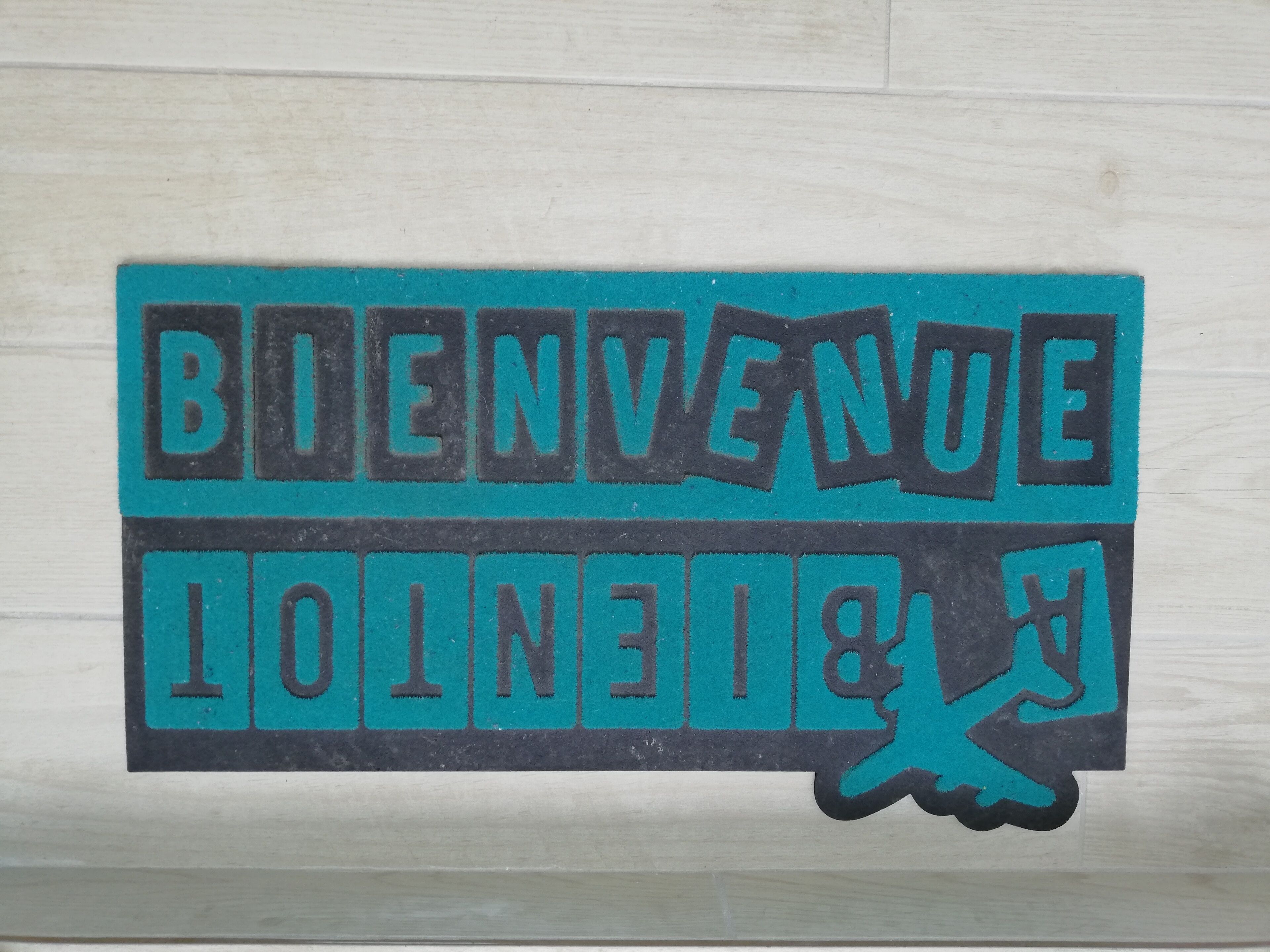 Een sticker met de tekst 'BIENVENUE' en een afbeelding van een hand.
