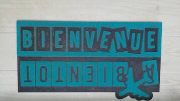 Een sticker met de tekst 'BIENVENUE' en een afbeelding van een hand.