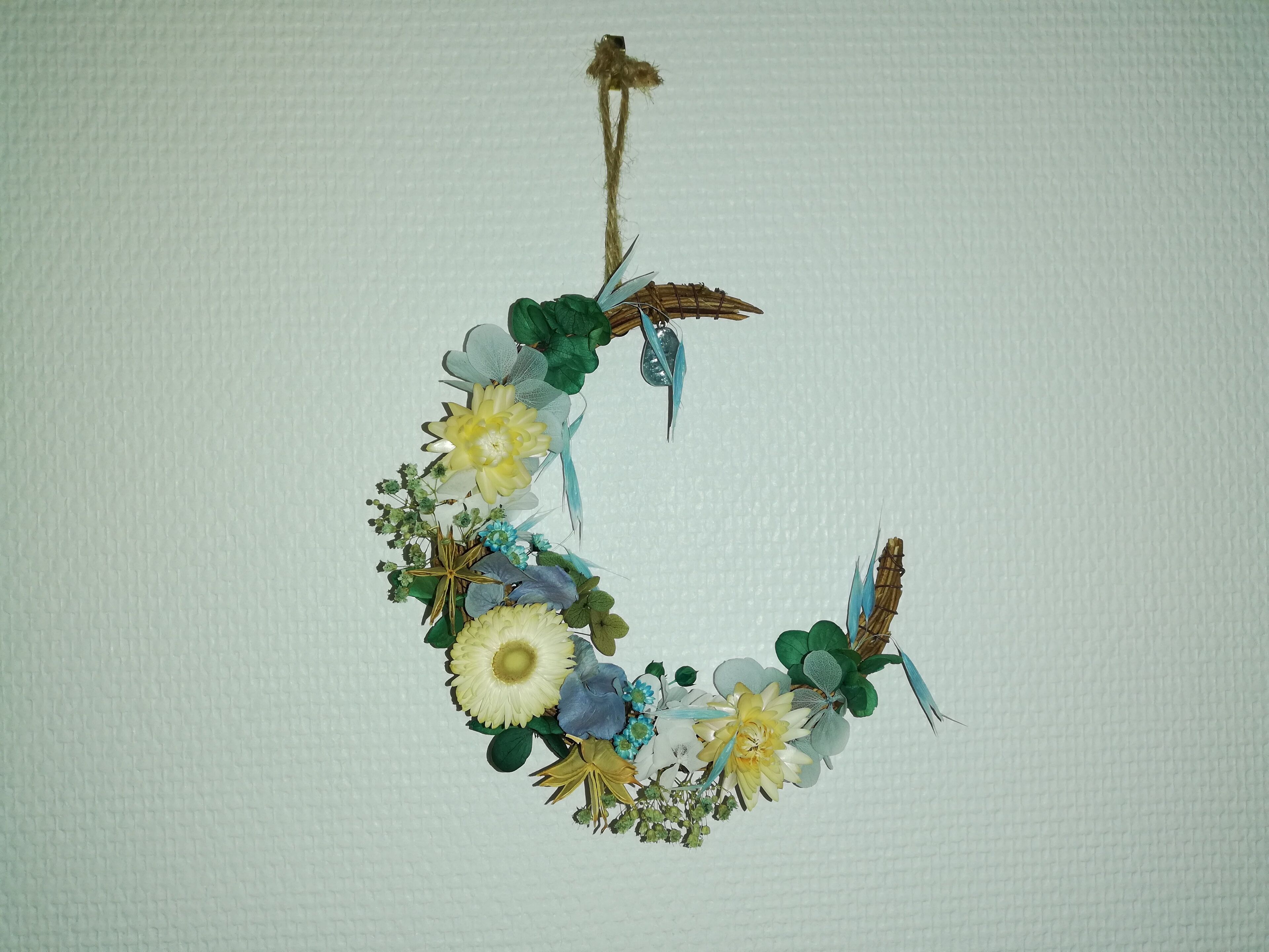 Een decoratieve krans met bloemen en bladeren.